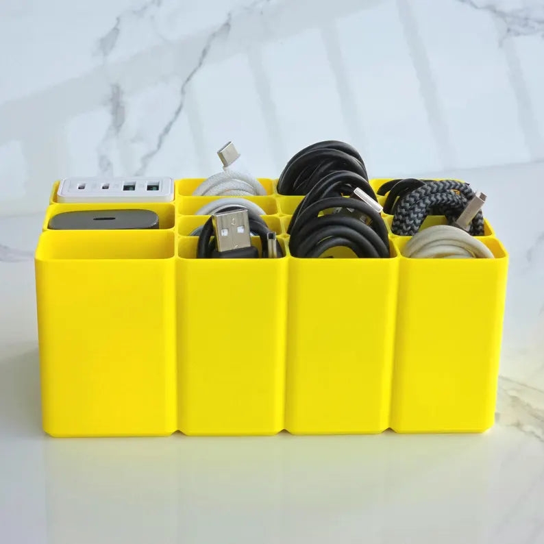 Yellow cable organizer with electronic devices on a marble background