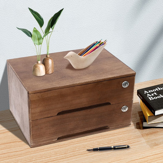 A two-drawer wooden organizer box with metal knobs sits on a tabletop. A small bird-shaped pencil holder and two mini vases with green stems rest on top.