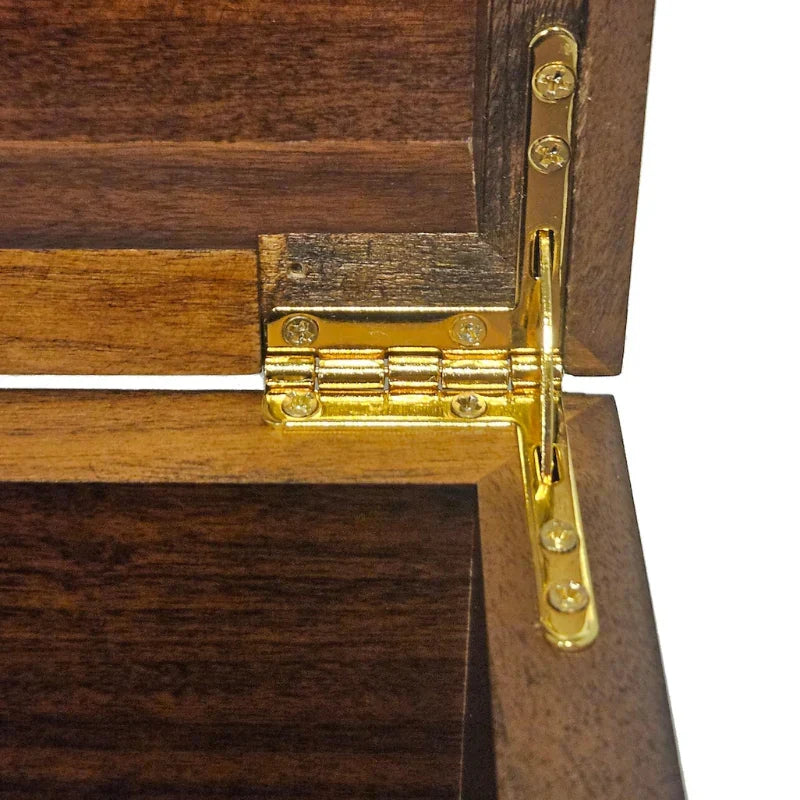 Close-up of a dark brown wooden box or cabinet corner with a polished gold-toned metal hinge attached to the outer corner.